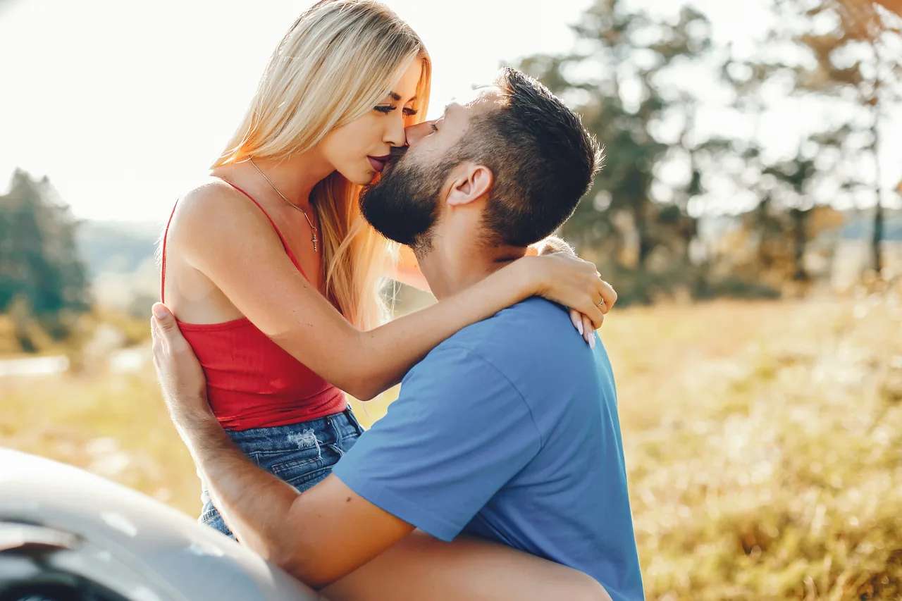 Two adults sharing an affectionate moment in a sunny park, illustrating Short-Term Herpes Dating, Open to Something More