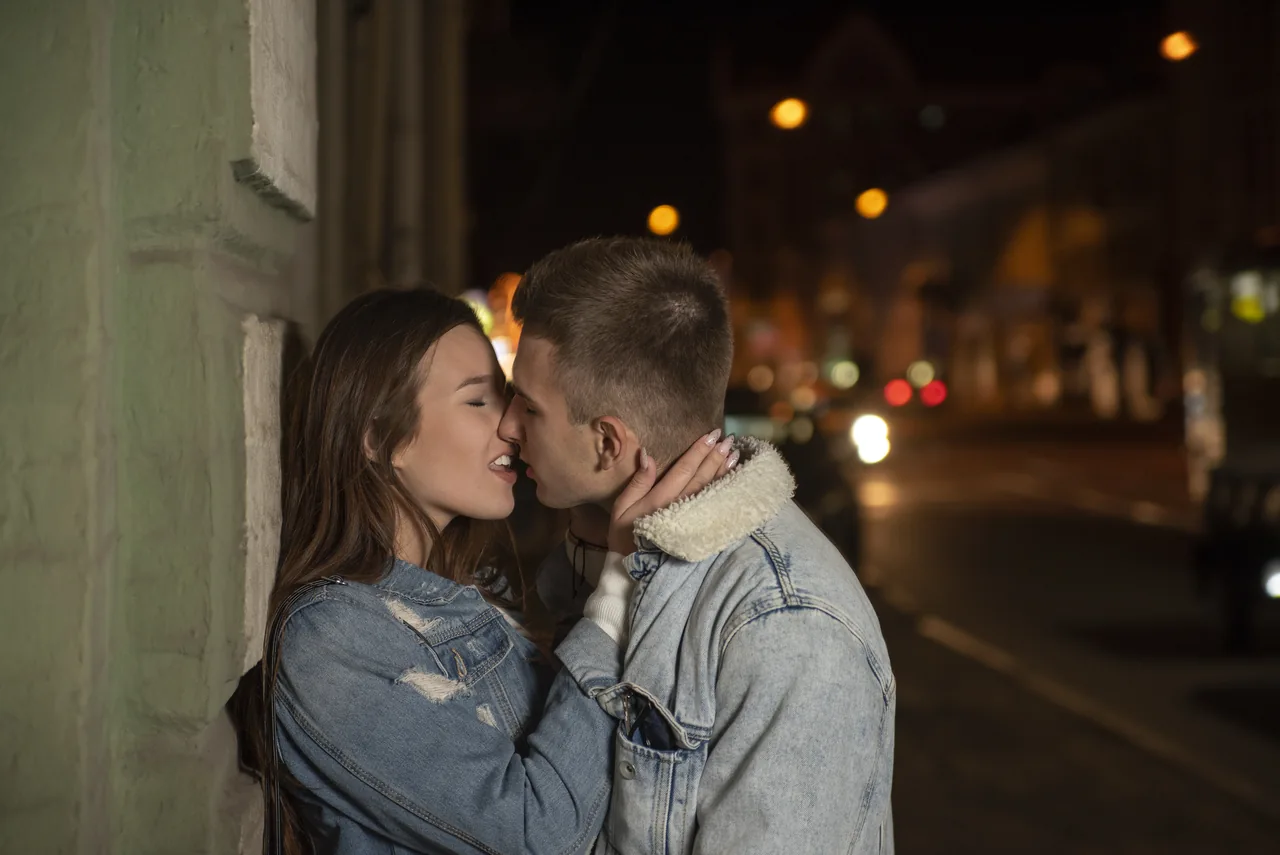 A couple kissing on a softly lit street, illustrating Herpes Dating for Night-Shift Singles Who Value Rest