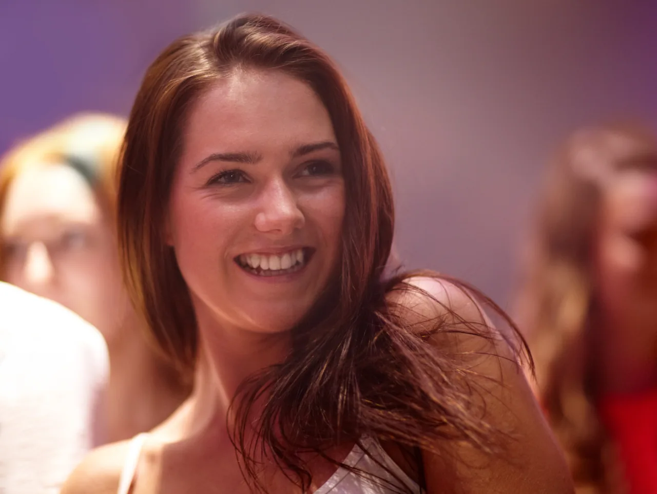A smiling adult enjoying a social event, illustrating Flirting with Herpes Singles and Reading the Response