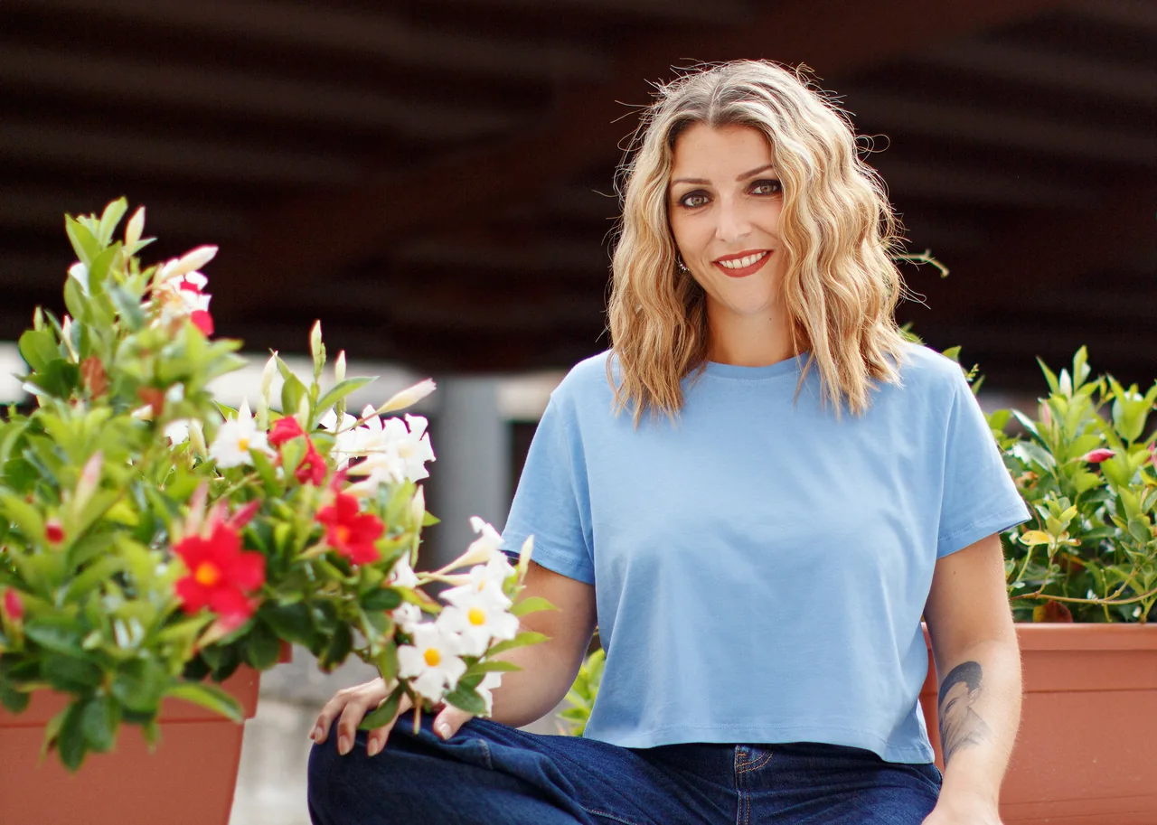 A smiling adult carrying flowers, illustrating Single Moms with Herpes: Date for the Life You Want