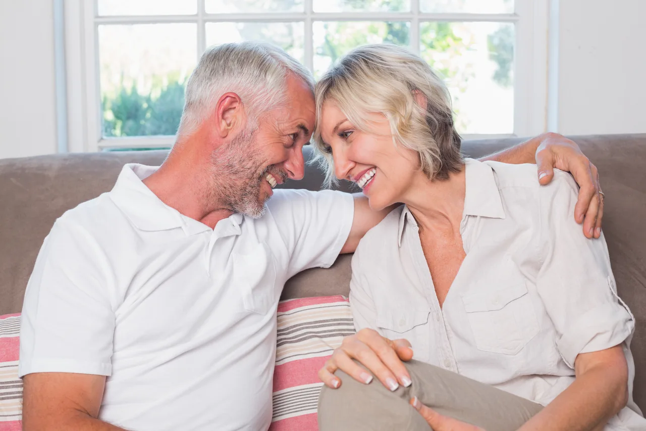 A mature couple sitting close on a sofa, illustrating Herpes Singles by Age and Stage of Life