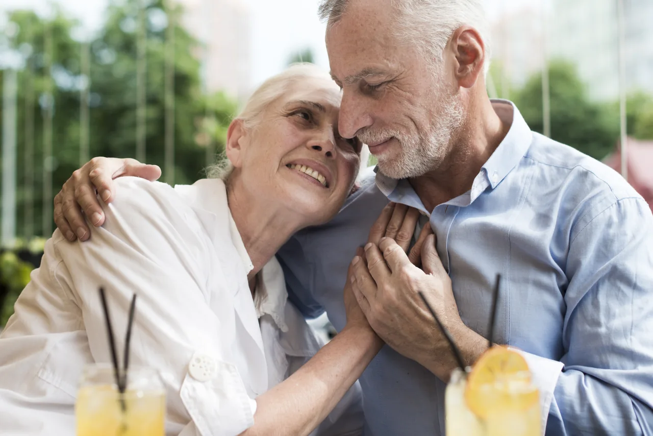 A mature couple sharing a quiet outdoor table, illustrating Herpes Dating for Companionship and Romance