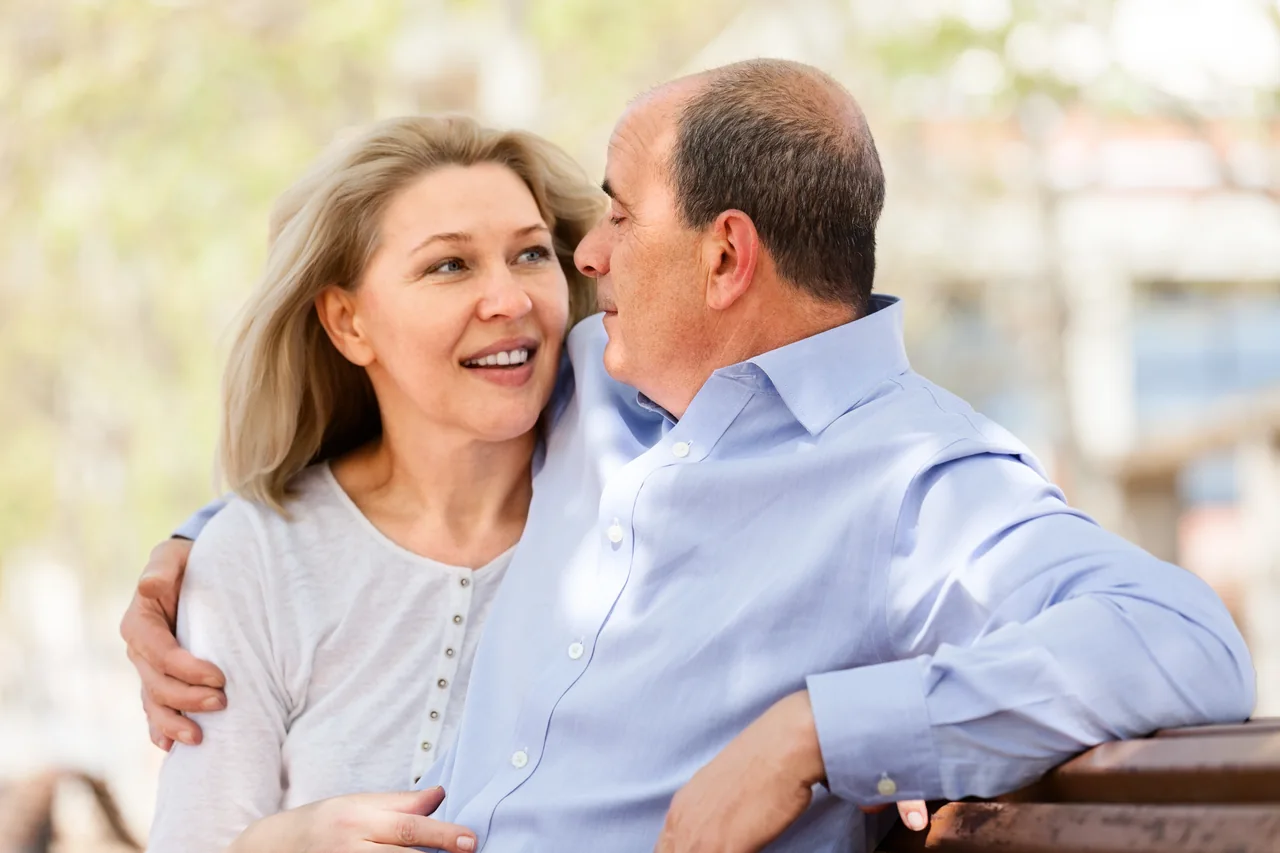 A mature couple sitting together on a park bench, illustrating Herpes Dating Over 40: Meet Singles Who Fit Your Life