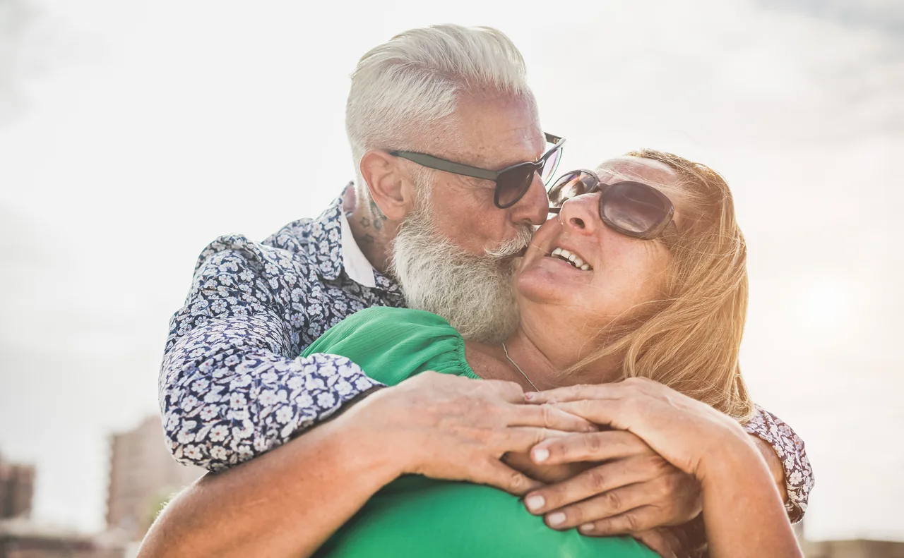 A mature couple sharing an affectionate embrace, illustrating Herpes Dating Over 60: Romance on Your Own Terms