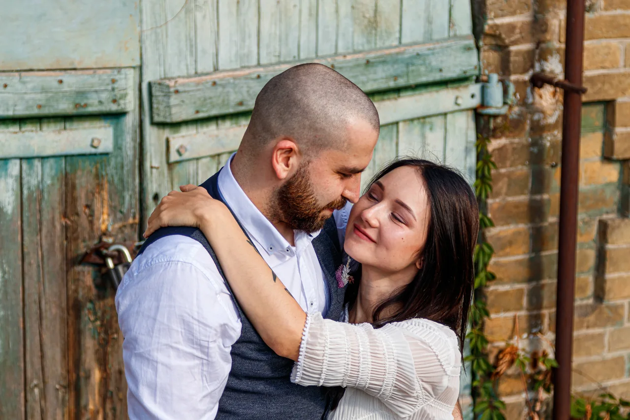 A couple embracing beside a brick wall, illustrating Meet HSV-2 Singles for Dating and Compatibility