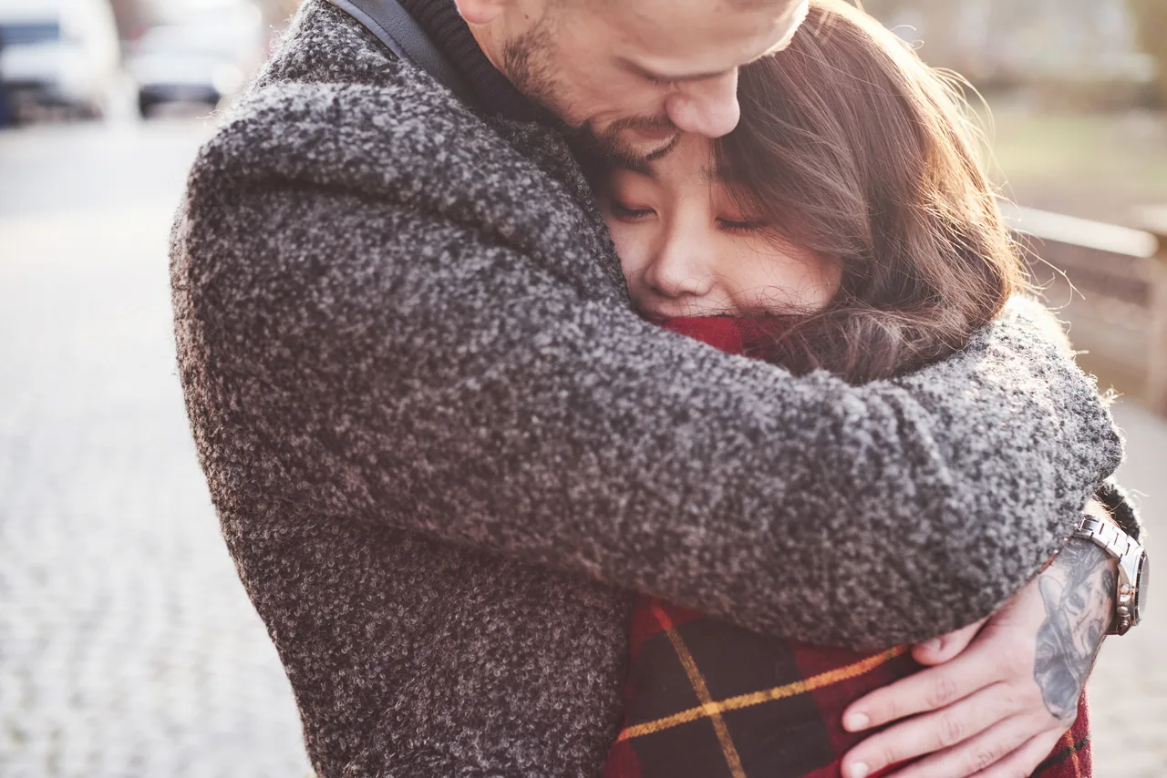 A couple embracing in warm outdoor clothing, illustrating Dating After Herpes Disclosure: What Comes Next